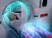 Person lying in an MRI scanner, with a digital overlay suggesting AI analysis of the images, illustrating hospital trials where AI reads scans quickly for same-day results.