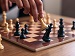 Macro shot of a wooden chess set with a king being toppled, representing 11 plus Verbal Reasoning logic and strategy.