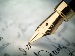 A gold-nibbed fountain pen writing on parchment paper.